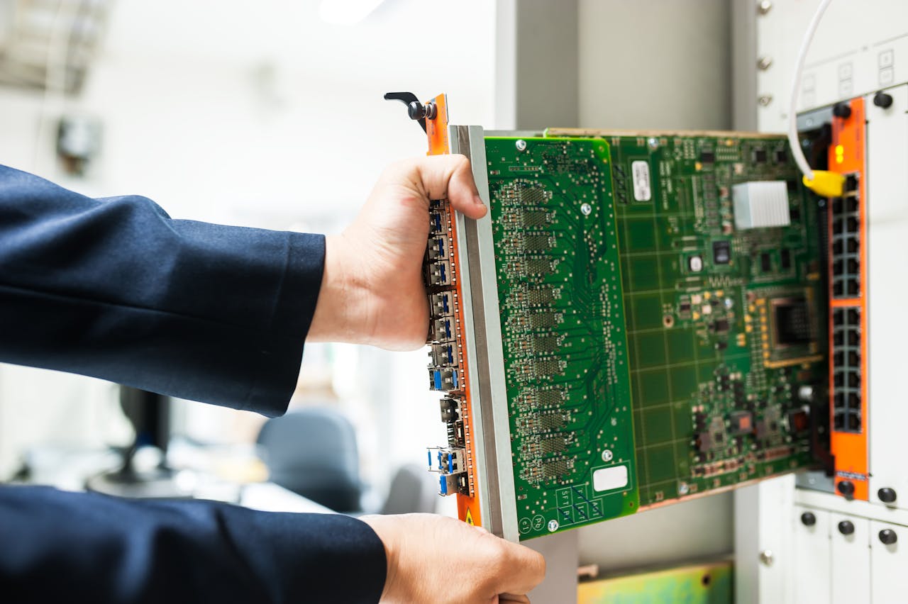 gallery-04 A technician inserts a circuit board into a server rack, illustrating technology and connectivity.
